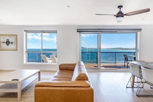 a living room with a couch and a view of the ocean at Amaroo in Gerroa