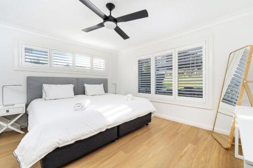 a bedroom with a bed and a ceiling fan at Amaroo in Gerroa