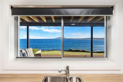 a kitchen window with a view of the ocean at Amaroo in Gerroa