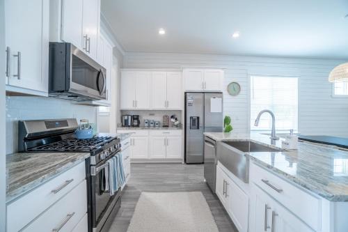 a kitchen with white cabinets and a stainless steel refrigerator at ~Spacious home near beach w/ game room and community pool~ in Orange Beach
