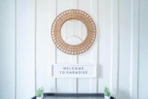 a welcome to paradise wreath in a room with a sign at ~Spacious home near beach w/ game room and community pool~ in Orange Beach