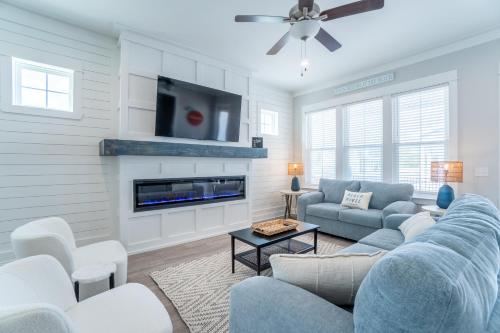 a living room with a blue couch and a tv at ~Spacious home near beach w/ game room and community pool~ in Orange Beach