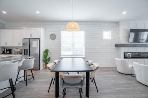 a kitchen and dining room with a table and chairs at ~Spacious home near beach w/ game room and community pool~ in Orange Beach
