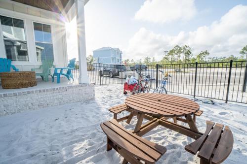 a patio with a wooden table and two benches at ~Spacious home near beach w/ game room and community pool~ in Orange Beach