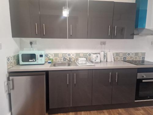 a kitchen with a sink and a microwave at Furnished 1 bedroom apartment in Bristol