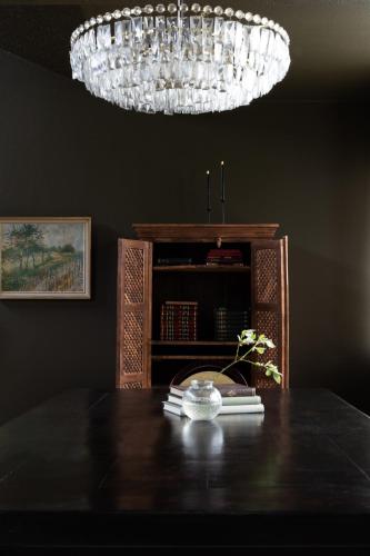 a table with books on it with a chandelier at Dalahótel in Laugar