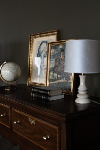a table with a lamp and a picture of a woman at Dalahótel in Laugar