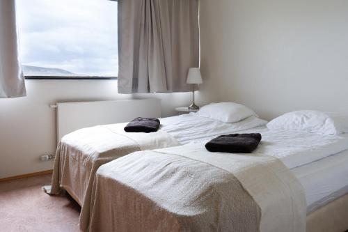 two beds in a hotel room with towels on them at Dalahótel in Laugar