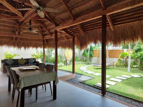 a dining room with a table and a patio at Halamanan Residences in Panglao