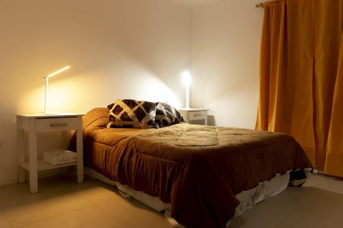 a bedroom with a bed with two lamps on it at Casa luz in Guaymallen