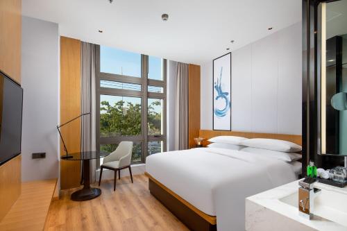 a bedroom with a bed and a desk and a television at Fairfield by Marriott Shanghai Hongqiao NECC in Shanghai