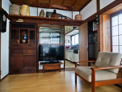 sala de estar con TV y silla en Asama Vista quiet home with view, Foreign Hosts en Miyota