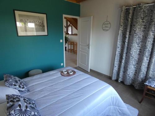 a bedroom with a large bed with a blue wall at Maison rénovée, 8 pers, animaux admis, jardin - FR-1-540-188 in Notre-Dame-de-Monts