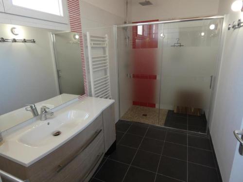 ein Badezimmer mit einem weißen Waschbecken und einer Dusche in der Unterkunft Maison Notre-Dame-de-Monts, 5 pièces, 8 personnes - FR-1-540-188 in Notre-Dame-de-Monts