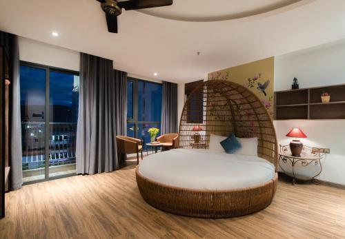 ein Schlafzimmer mit einem ovalen Bett in einem Zimmer mit Fenstern in der Unterkunft Aaron Boutique Hotel in Nha Trang