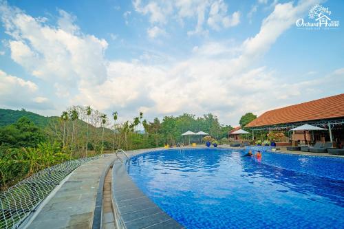 einen Pool in einem Resort mit blauem Wasser in der Unterkunft Orchard Home Nam Cat Tien in Cat Tien