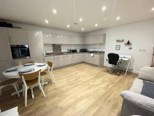 a living room with a kitchen and a table and chairs at Cozzy apartment in Camberwell in London