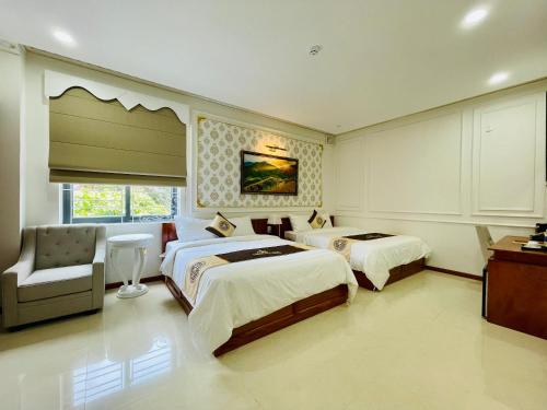 a hotel room with two beds and a chair at NEW PALACE HOTEL in Quang Ngai