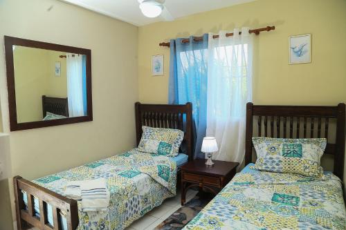 sypialnia z 2 łóżkami i lustrem w obiekcie Apto CALETA BEACH 3HAB w mieście La Romana