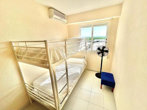 a bunk bed room with two bunk beds and a window at Apartamento con Piscina 3 habitaciones in Sueca