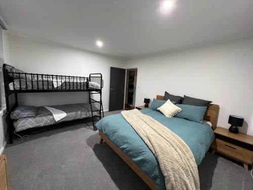 a bedroom with a bed and a bunk bed at Cosy Eildon Getaway in Eildon