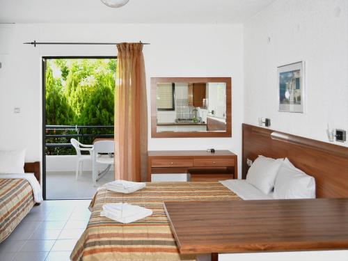 Habitación de hotel con 2 camas y espejo en Kamares Apartments ΕΕ en Poros