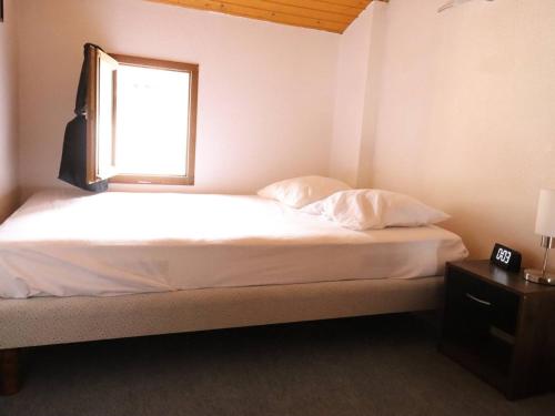 een slaapkamer met een wit bed en een raam bij Maison Les Mathes, 1 pièce, 4 personnes - FR-1-738-7 in Les Mathes