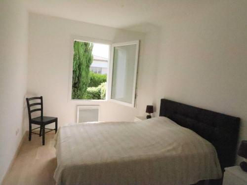 - une chambre avec un lit, une fenêtre et une chaise dans l'établissement Appartement Meschers-sur-Gironde, 3 pièces, 4 personnes - FR-1-738-1, à Meschers-sur-Gironde