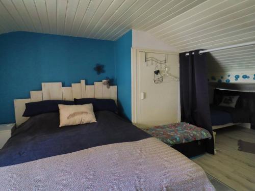une chambre avec un lit et un mur bleu dans l'établissement Maison 4 pers. avec piscine, tennis, et parking - Proche La Palmyre - FR-1-738-20, aux Mathes