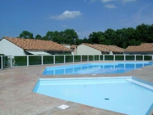 - une grande piscine en face de certaines maisons dans l'établissement Maison 4 pers. avec piscine, tennis, et parking - Proche La Palmyre - FR-1-738-20, aux Mathes