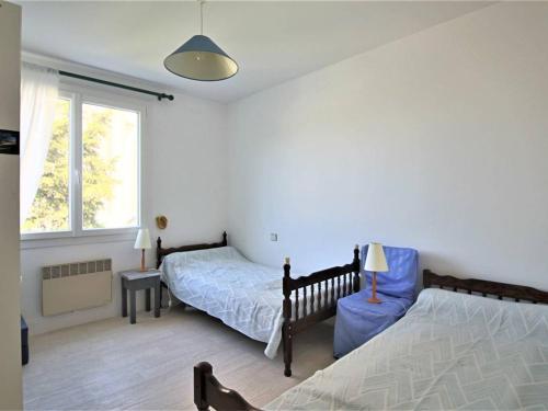 une chambre avec deux lits et une fenêtre dans l'établissement Appartement lumineux pour famille à Royan, quartier calme près du marché, balcon et parking gratuit - FR-1-738-26, à Royan