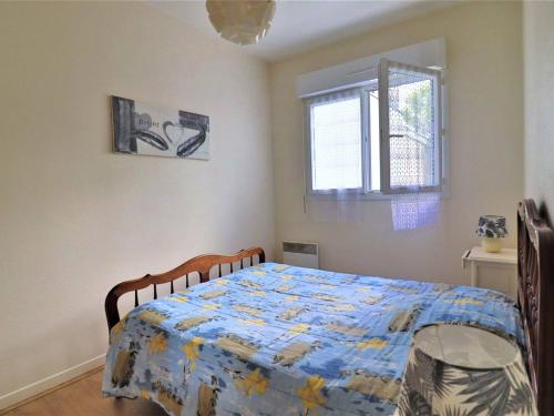 une chambre avec un lit avec une couette dessus dans l'établissement Appartement lumineux à Royan - proche gare et plage, 6 pers., terrasse, animaux admis - FR-1-738-24, à Royan