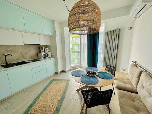 a kitchen and living room with a table and a couch at Sim Seaside Beach Resort in Mamaia Sat/Năvodari