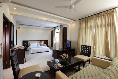 sala de estar amplia con cama y sofá en The Legend Inn Delhi, en Nueva Delhi