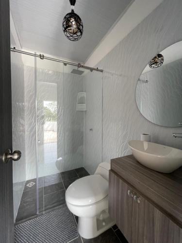 a bathroom with a toilet and a sink and a mirror at cabaña la bonita habitacion 302 in Doradal