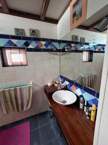 een badkamer met een wastafel en een spiegel bij La maison des artistes in Saint-Leu