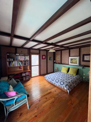 een slaapkamer met een bed en een bank in een kamer bij La maison des artistes in Saint-Leu