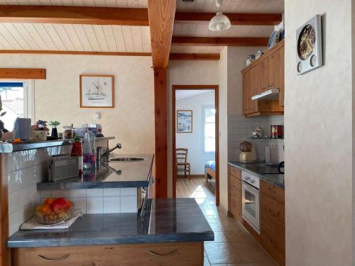 - une cuisine avec un comptoir dans une pièce dans l'établissement Charmante maison 4 pers. à 200m plage et port, terrasse, TV, ménage inclus - FR-1-224B-199, à Noirmoutier-en-l'lle