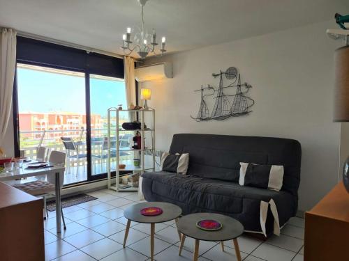 un salon avec un canapé et une table dans l'établissement Appartement 2 pièces avec climatisation et parking à 50m de la plage au Cap d'Agde - FR-1-249-396, au Cap d'Agde