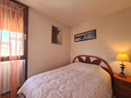 une chambre avec un lit blanc et une fenêtre dans l'établissement Appartement 2 pièces avec climatisation et parking à 50m de la plage au Cap d'Agde - FR-1-249-396, au Cap d'Agde