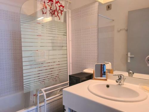 une salle de bain blanche avec un lavabo et un miroir dans l'établissement Appartement 2 pièces avec climatisation et parking à 50m de la plage au Cap d'Agde - FR-1-249-396, au Cap d'Agde