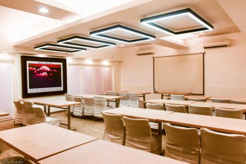 a classroom with tables and chairs and a chalkboard at The Legend Inn Delhi in New Delhi
