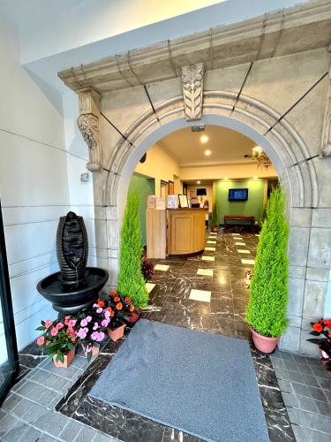 een boog in een lobby met een fontein en bloemen bij Melur Inn in Cameron Highlands