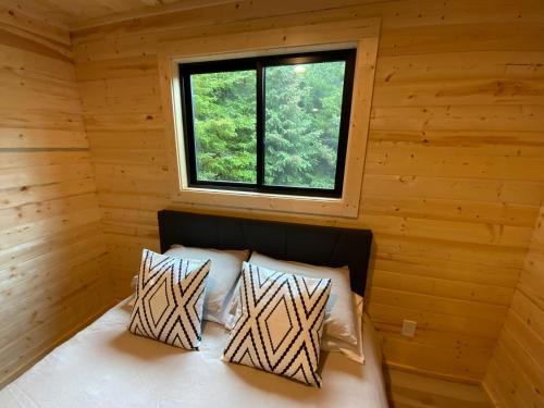 a bedroom in a log cabin with a window at Oyster Lady Homer, AK in Homer