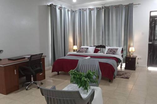 1 dormitorio con 1 cama grande, escritorio y escritorio en Siswi (The Nest)- The place to be., en Bungoma