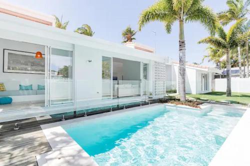 a large swimming pool in front of a house at Poinciana House—Luxury Noosa Retreat close to Beach in Noosa Heads