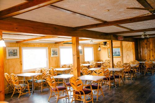 Boularderie East的住宿－Travels Inn Victoria County，用餐室设有桌椅和窗户。