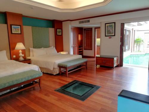 a hotel room with two beds and a pool at Wonderland Private Pool Villas at Port Dickson in Port Dickson