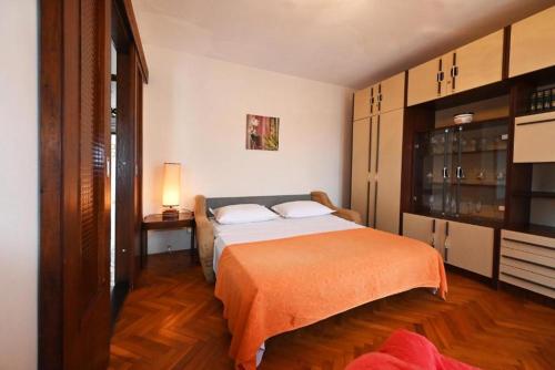 1 dormitorio con 1 cama con manta naranja en Apartments Mihovilovic - 50 m from beach, en Slatine