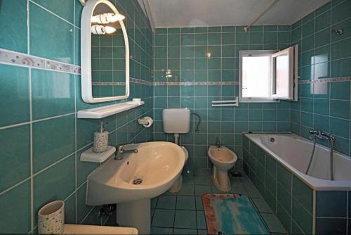 baño verde con lavabo, bañera y aseo en Apartments Mihovilovic - 50 m from beach, en Slatine